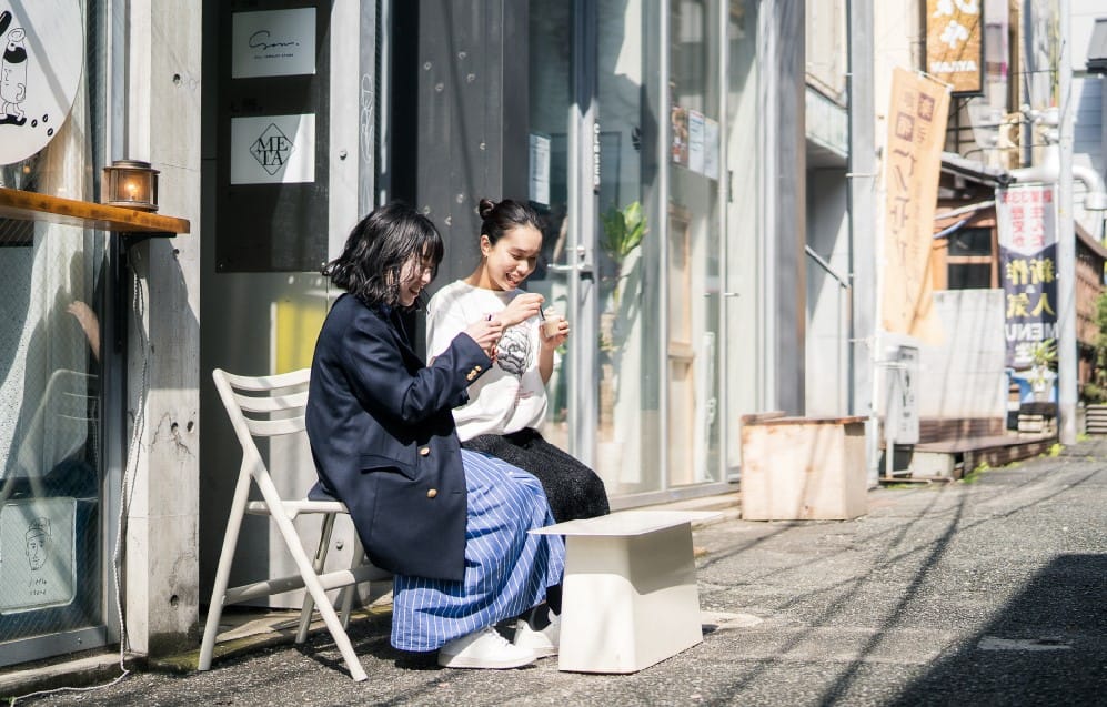 外で座る二人の女性